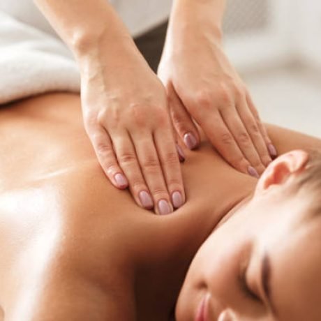 Young woman enjoying therapeutic neck massage in spa center, closeup