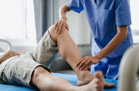 Close up of Physiotherapist working with patient on the bed in clinic